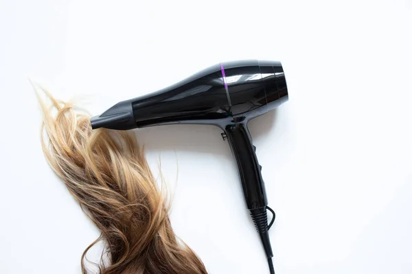 女孩用白色背景的吹风机 吹风机和发型师擦干她的头发 — 图库照片