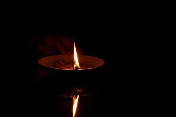 在黑暗中 一根沾满油的绳子躺在盘子里 在姑娘手里燃烧 在镜子上 一根自制的蜡烛在家里燃烧 — 图库照片