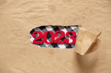 Yırtık kahverengi kağıttan 2023 yıl, mutlu yıllar 2023.