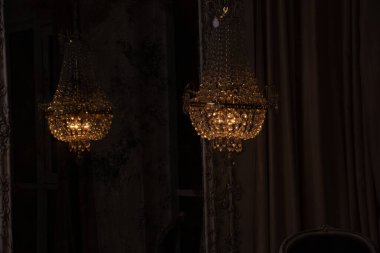 Evdeki aynanın yanında asılı kristal eski avize, eski model iç döşeme, avize.