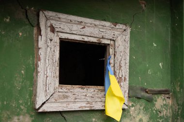 The flag of Ukraine hangs on the window of a destroyed residential building, the war and the shelling of Russian residential buildings in Ukraine