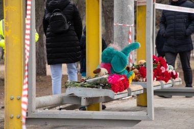 Toys and flowers lie at a trolleybus stop next to a house blown up by a Russian rocket on Pobeda in the city of Dnepr in Ukraine during the war, the memory of those who died