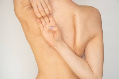 The back of a young thin girl on a white background without retouching and processing, body