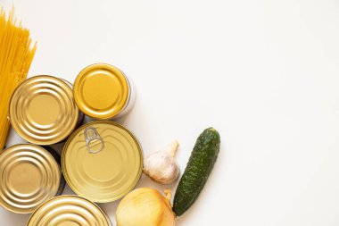 Canned food different, spaghetti and onion, cucumber and garlic on a white background, a set of products lies on a white