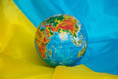 The globe lies on the flags of Ukraine close-up