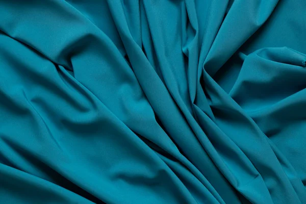 Blue wrinkled plain fabric as background close up