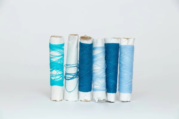 白い隔離された背景のスプール上のさまざまな色合いの青い糸 ファッション — ストック写真