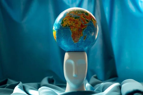 Globe Staat Een Sculptuur Van Een Menselijk Hoofd Een Blauwe — Stockfoto