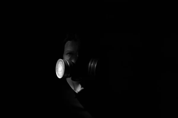 一个戴着防毒面具的女孩在黑暗中的脸 对生命构成威胁 — 图库照片
