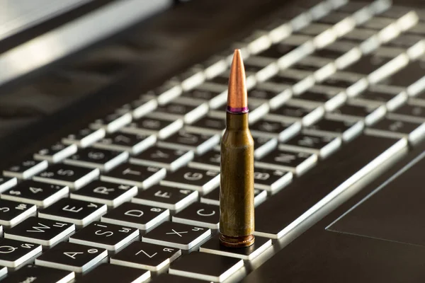 黒いノートパソコンのキーボードに弾丸が一発 — ストック写真