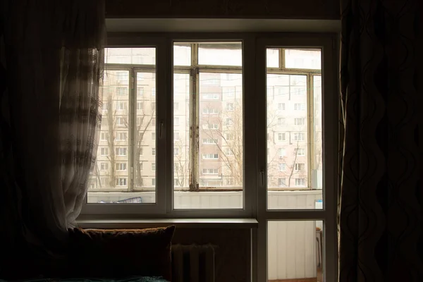 暗い部屋とウクライナの窓の外の多階建ての建物の中に古い窓を見下ろすアパートのリビングベッドルーム — ストック写真