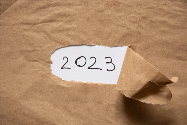 中间有一个洞的棕色纸和2023年的文本 新年快乐 — 图库照片