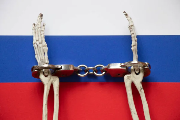 ロシア 法と正義の旗に手錠をかけるスケルトン手 — ストック写真