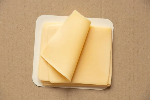 Katı Peynir Dilimleri Kahverengi Bir Kartondan Yapılmış Yakın Plan Yiyecek — Stok fotoğraf