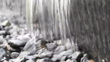 Parklardaki çeşme taşların ve akıntıların üzerine düşüyor, video arka planda