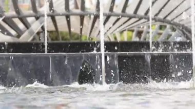 Parklardaki çeşme taşların ve akıntıların üzerine düşüyor, video arka planda