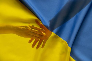 İki adam, Ukrayna bayrağı, dostluk ve birliğin arka planında el sıkışarak dostluk ve selamlaşmanın bir işareti olarak ellerini birbirlerine uzattılar.