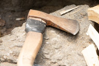 Yazın ormanda bir granit taşın üzerinde çalışan eski bir balta yakacak odun keserken, odun kesmek için bir alet, bir oduncu