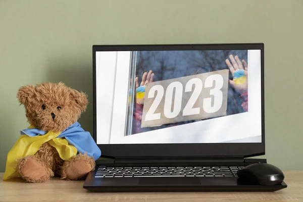 Zdjęcie Ekranie Laptopa Dziewczynki Trzyma Sztandar Tekstem 2023 Flaga Ukrainy — Zdjęcie stockowe