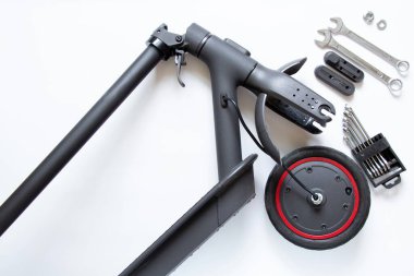 Parçalanmış elektrikli scooter, tekerlek patlaması ve yerine yeni bir tekerlek, elektrik nakil onarımı ve servis.