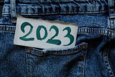 2023, kot pantolon cebinde bulunan bir kağıtta yeşil boyayla yazılmış. Mutlu yıllar 2023, afiş ve arka plan.