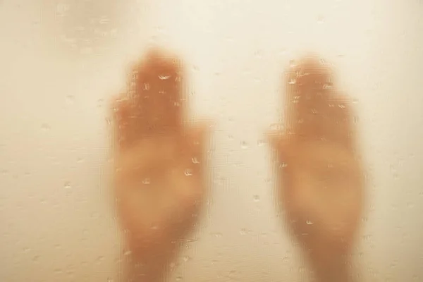 シャワーのクローズアップのウェットガラスの女性の手 シャワーに女の子が浴びる 彼女の手はガラスにあります — ストック写真
