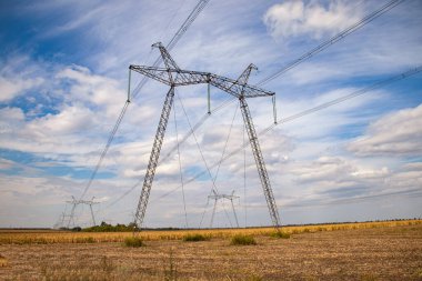 Yazın Ukrayna 'daki güç iletim kulesi. Yüksek voltajlı elektrik iletim hattı kabloları yaz aylarında mısır tarlasını destekliyor.