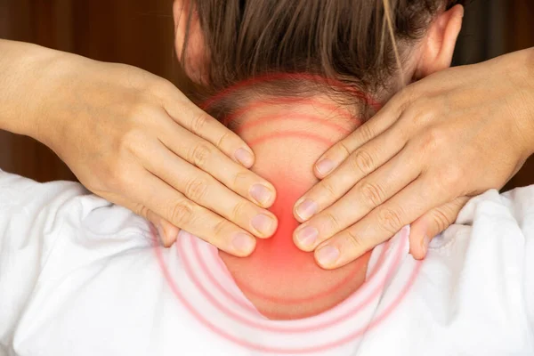 A girl holds her hands behind her neck at home, sore neck, acute pain in the neck