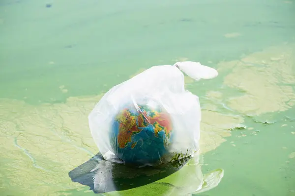 Globo Terrestre Una Bolsa Plástico Flota Río Sucio Ucrania Contaminación —  Fotos de Stock