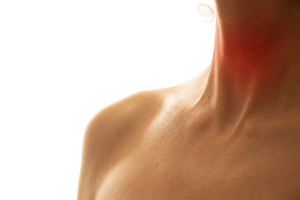 Female throat with a red spot in the middle of the neck on a light background, sore throat, sore throat, flu and health