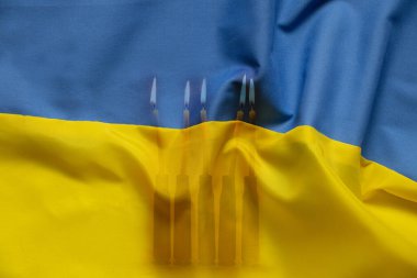 Burning candles and empty rifle cartridges on the flag of Ukraine. As a symbol of war and victims of the war in Ukraine, war and grief clipart