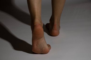 Kadınların çıplak ayakları, beyaz bir arka planda gölgelerde, ayaklarda, çıplak ayaklarda rötuş yapmadan.
