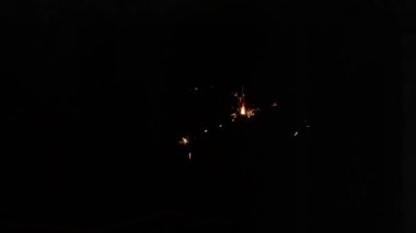 Ukrayna 'da karanlıkta, yeni yılı kutlayan bir adamın elinde maytap.
