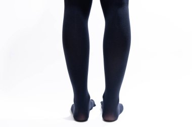 Beyaz arka planda siyah taytlı kadın bacakları, kadın naylon çorapları, moda.