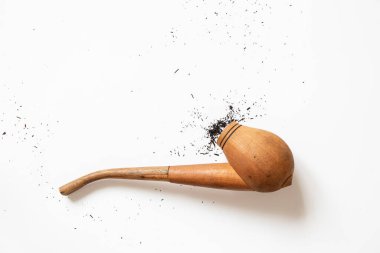 Etrafa saçılmış sigara piposu ve küller yakın plan beyaz bir fonda yatıyor.