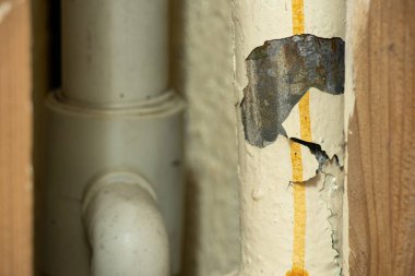 Tamiri olmayan bir apartmanın banyosundaki eski paslı borular, tesisatçı...