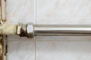 Tamiri olmayan bir apartmanın banyosundaki eski paslı borular, tesisatçı...