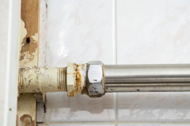 Tamiri olmayan bir apartmanın banyosundaki eski paslı borular, tesisatçı...