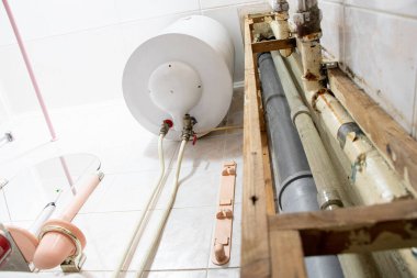 Water heater and pipes in a residential apartment after replacing the pipe with a new one, bathroom and plumbing repairs clipart