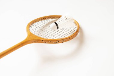 Old wooden racket and shuttlecock closeup on a white background, sport and hobby