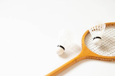 Old wooden racket and shuttlecock closeup on a white background, sport and hobby