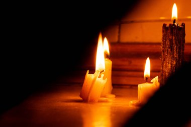 Karanlıkta mumlar, yerde gölgeler, mum alevi, ateş, ışık yok.