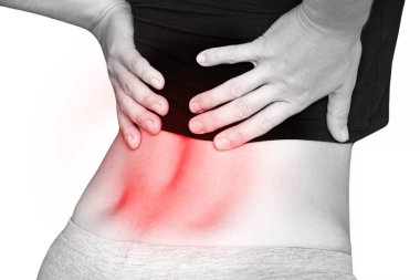 Sırtındaki ağrıdan dolayı sırtını tutan genç bir kız beyaz arka planda oturuyor, sırt ağrısı, şiddetli ağrı.