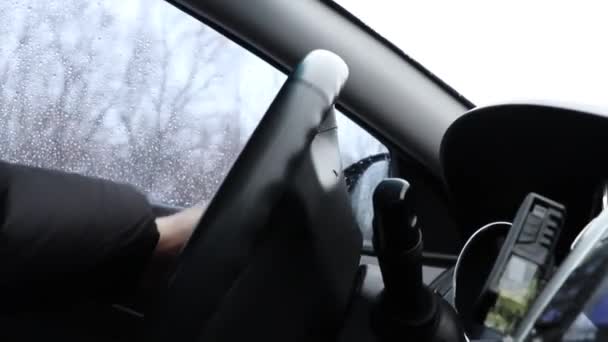 冬の日にウクライナの街を車で運転する男 ステアリングホイールを保持し 車で運転し 車の中で見る — ストック動画