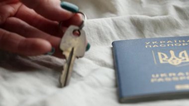 Bir kadının eli evin anahtarlarını Ukrayna pasaportunun yanına koydu. Masaya koydu, Ukrayna 'dan ayrıldı, evi terk etti.