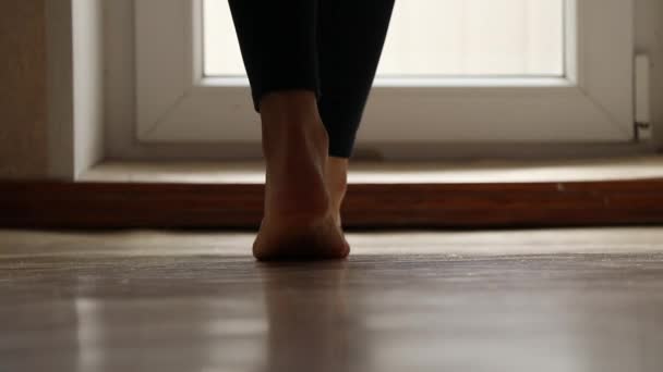 女の子は家のバルコニーに裸足を歩きました 彼女の足は家の床にありました — ストック動画