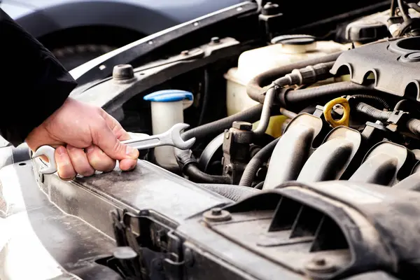 Car care, maintenance and repair, auto mechanic, hand and wrench for car repair, engine problem and diagnosis, car repair