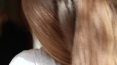 Evde ellerini boynunun arkasında tutan bir kız var. Yorgun, boyun ağrısı, boyun masajı.