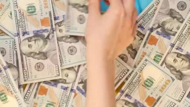 一个女人的手在收集挂在乌克兰国旗上的100美元钞票 — 图库视频影像