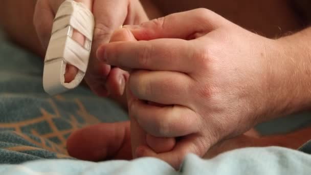 Homem Corta Unhas Dos Pés Com Dedo Quebrado Cama Casa — Vídeo de Stock